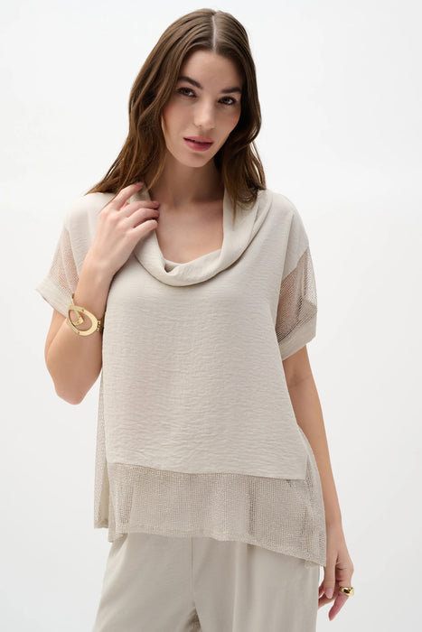 Woman wearing a cowl collar boxy top with sheer gauze layers and dolman sleeves, styled for summer layering, travel, or modern casual chic outfits.