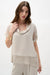 Woman wearing a cowl collar boxy top with sheer gauze layers and dolman sleeves, styled for summer layering, travel, or modern casual chic outfits.