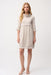 Woman wearing a knee-length cocoon dress with a cowl neckline, patch pockets, and fold-back cuff sleeves, styled for office wear, travel, or casual elegant occasions.
