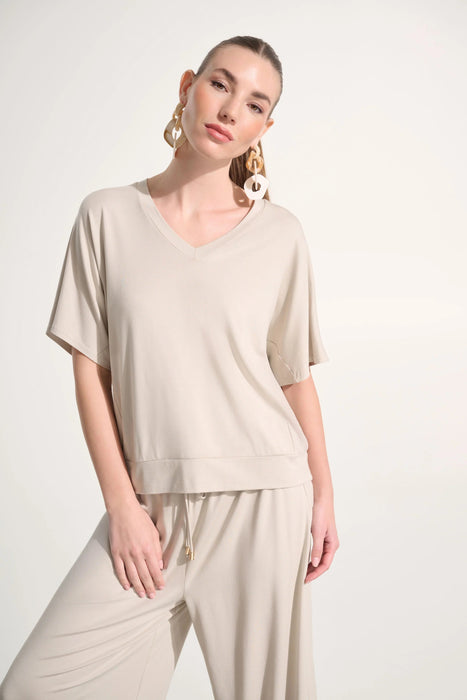 Woman wearing Joseph Ribkoff jersey dolman sleeve boxy top styled for casual chic, office wear, travel, and modern everyday fashion looks.