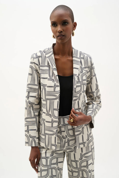 Woman wearing Joseph Ribkoff geometric print straight-cut jacket, featuring a tailored silhouette, open-front design, structured lapels, and a bold modern pattern.