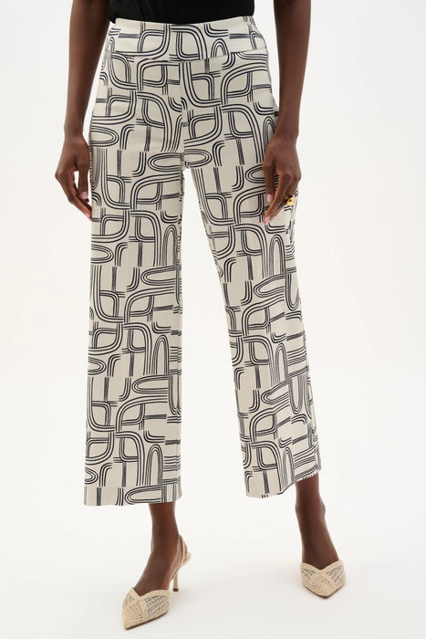 Woman wearing Joseph Ribkoff geometric print wide leg pants, featuring a high-waisted fit, cropped length, bold abstract pattern, and a relaxed modern silhouette.
