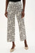 Woman wearing Joseph Ribkoff geometric print wide leg pants, featuring a high-waisted fit, cropped length, bold abstract pattern, and a relaxed modern silhouette.