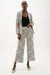 Woman wearing Joseph Ribkoff geometric print wide leg pants, featuring a high-waisted fit, cropped length, bold abstract pattern, and a relaxed modern silhouette.
