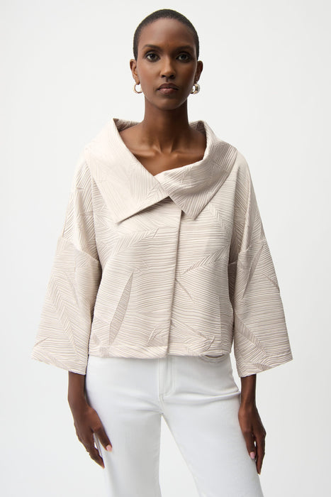 Woman wearing a beige textured jacket with leaf patterns and overlap collar from Joseph Ribkoff