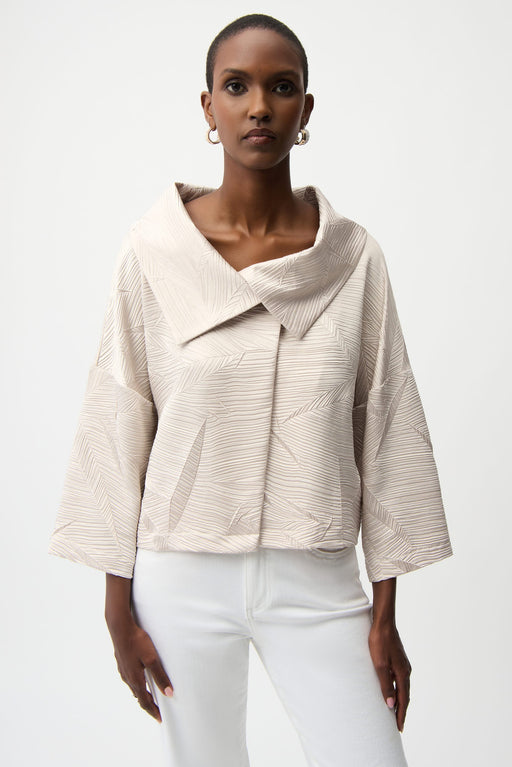 Woman wearing a beige textured jacket with leaf patterns and overlap collar from Joseph Ribkoff