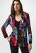 Woman wearing a colorful patterned blazer jacket with newspaper print