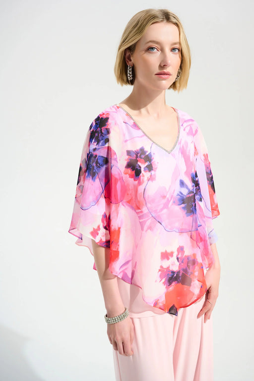 Woman wearing a rhinestone-trimmed v-neck poncho top with lightweight floral chiffon overlay from Joseph Ribkoff