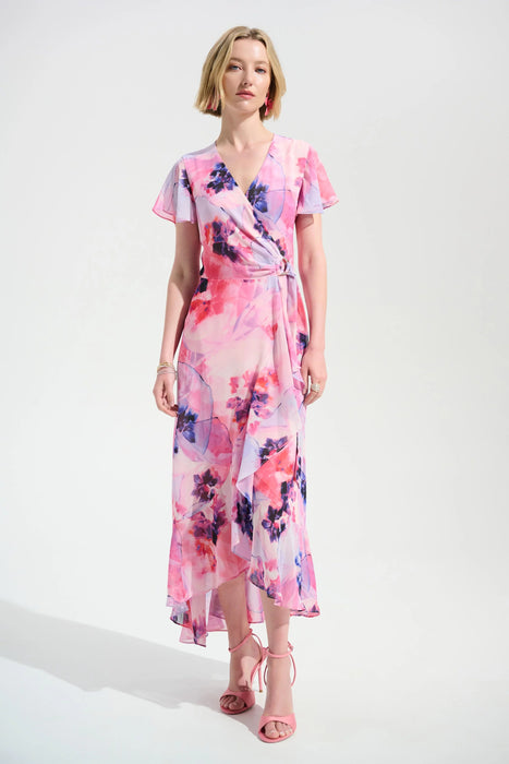Woman wearing a pink floral wrap dress with high low ruffle hem from Joseph Ribkoff