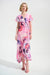 Woman wearing a pink floral wrap dress with high low ruffle hem from Joseph Ribkoff