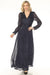 Woman wearing a navy blue metallic long evening dress with wrap v-neck and long puff sleeves from Joseph Ribkoff