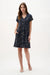 Woman wearing a navy and off-white abstract print trapeze dress with short sleeves and relaxed silhouette for a chic everyday look
