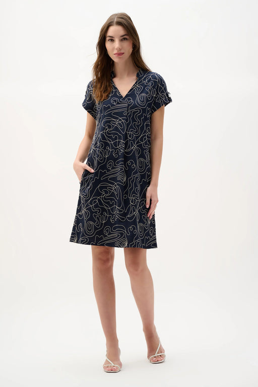 Woman wearing a navy and off-white abstract print trapeze dress with short sleeves and relaxed silhouette for a chic everyday look