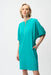 Woman wearing a turquoise shift dress with puff sleeves, zip front and side pockets from Joseph Ribkoff