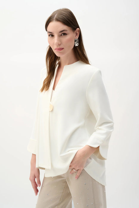 Woman wearing a solid off-white swing jacket with statement button and 3/4 sleeves from Joseph Ribkoff