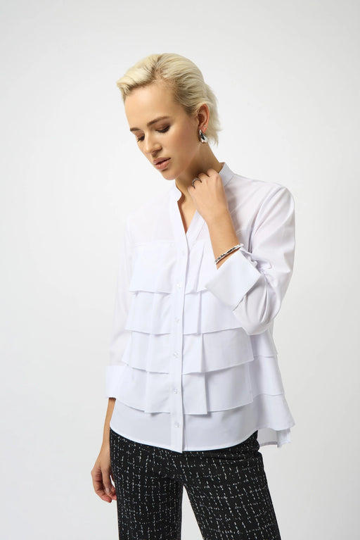 Woman wearing a white woven blouse with layered ruffles at the front and button closure