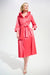 Woman wearing a pink pleated midi flared dress with double collar, belt, and side pockets from Joseph Ribkoff