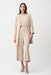 Woman wearing a parchment longline blazer with notched collar and open front, styled with a matching minimalist outfit.