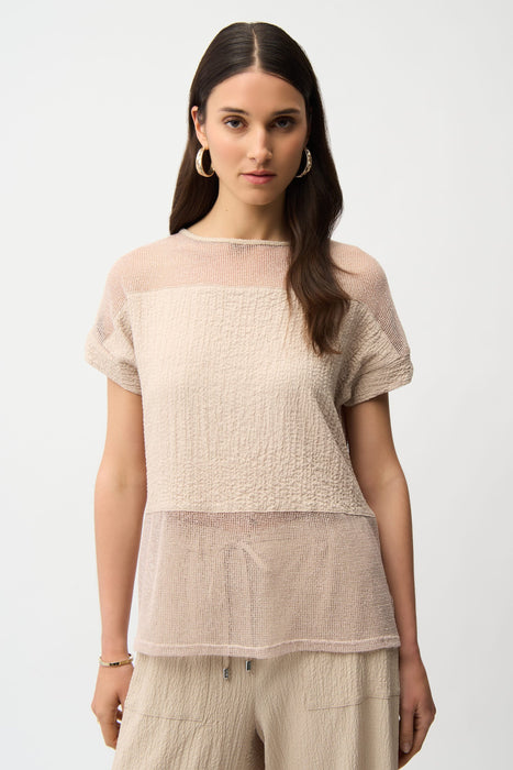 Woman wearing a beige textured short sleeve top with sheer mesh insert from Joseph Ribkoff