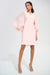 Woman wearing light pink A-line above the knee dress with sheer cape sleeves and slit neck from Joseph Ribkoff