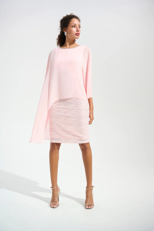 Woman wearing a light pink textured sheath dress with lightweight chiffon poncho overlay from Joseph Ribkoff