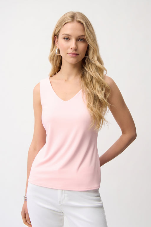 Woman wearing a petal pink sleeveless V-neck tank top, styled for office wear, travel, casual outings, or layered under a blazer for a polished look.