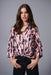 Woman wearing a pink satin blouse with black animal pattern and half tuck design from Joseph Ribkoff