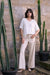 Woman wearing Joseph Ribkoff rhinestone denim wide leg jeans, featuring embellished neutral denim, wide leg silhouette, full length, and a flattering modern fit.