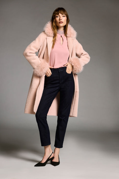 Woman wearing a pink coat with detachable faux fur trim and long sleeves from Joseph Ribkoff