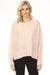 Woman wearing a light pink-colored crew neck sweater top with studs and long sleeves from Joseph Ribkoff