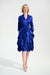 Woman wearing Joseph Ribkoff royal sapphire fit and flare dress with cascading ruffle skirt, V-neckline, three-quarter sleeves, and sash belt.