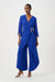 Woman wearing a blue wrap jumpsuit with 3/4 sleeves and cropped tulip wide leg from Joseph Ribkoff