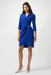 Woman wearing a blue wrap sheath dress with pleats and 3/4 sleeves