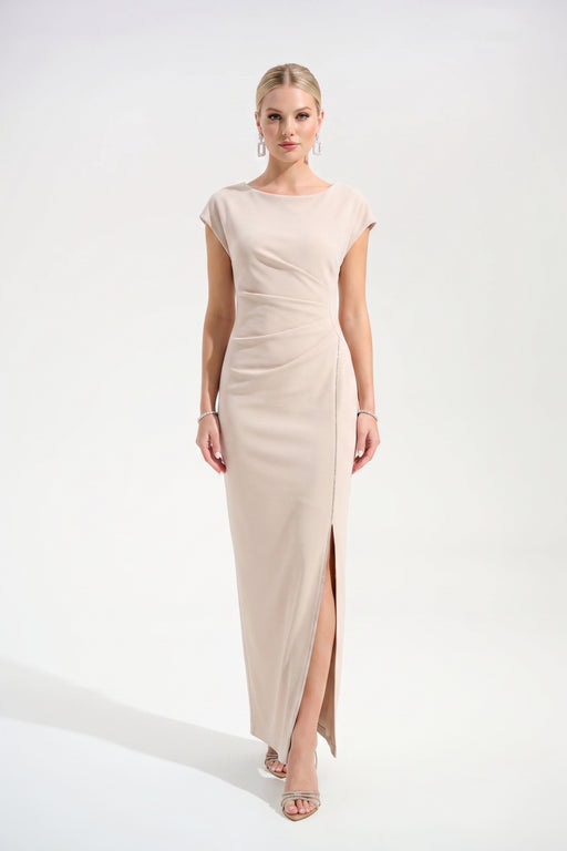 Woman wearing a beige long evening dress with ruching at the waist and rhinestone-trimmed side slit from Joseph Ribkoff