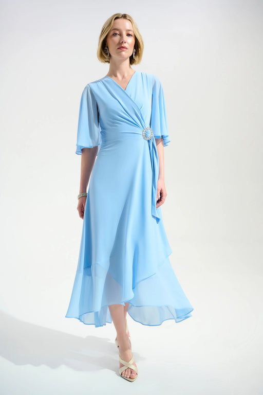 Woman wearing a light blue dress with wrap neck and ruffle hem from Joseph Ribkoff