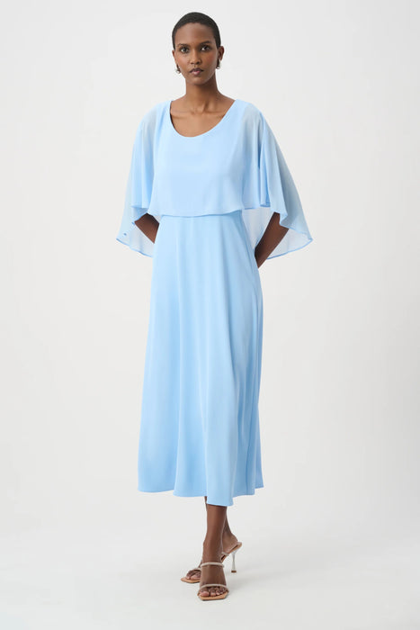 Woman wearing a light blue A-line maxi dress with lightweight chiffon overlay from Joseph Ribkoff