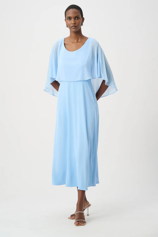 Woman wearing a light blue A-line maxi dress with lightweight chiffon overlay from Joseph Ribkoff