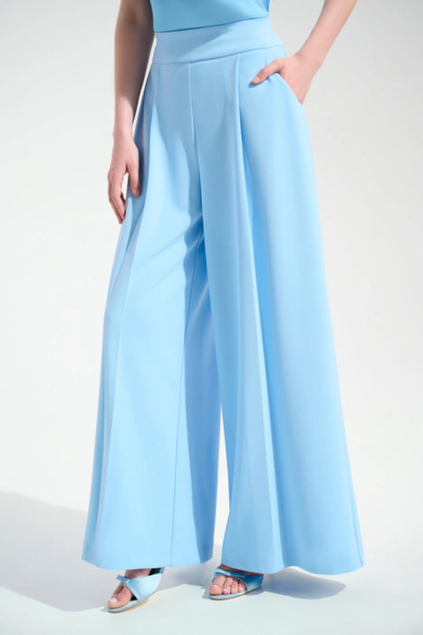 Woman wearing a light blue pleated wide leg pants with side pockets and high waist pull on waistband from Joseph Ribkoff