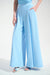 Woman wearing a light blue pleated wide leg pants with side pockets and high waist pull on waistband from Joseph Ribkoff