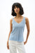 Woman wearing a metallic ribbed knit camisole with rhinestone details and V-neckline, styled for evening events, cocktail parties, date nights, or chic layered outfits.
