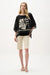 Woman wearing Joseph Ribkoff tropical print poncho top in black and beige, featuring a sheer flowy overlay, relaxed silhouette, and elegant lightweight design.