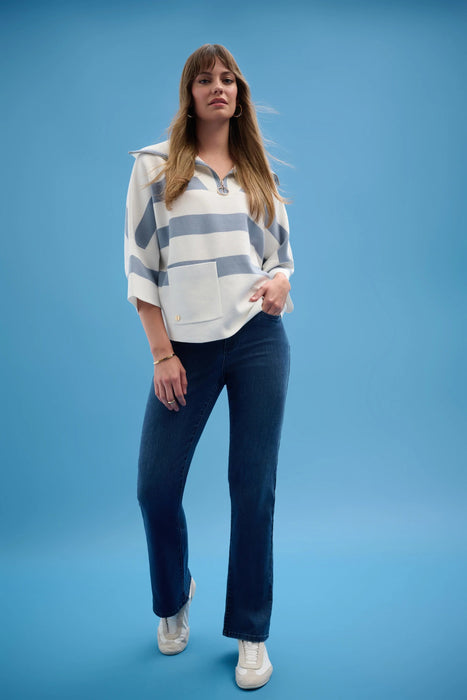 Woman wearing Joseph Ribkoff stripe print boxy sweater with zipped collar, featuring a relaxed fit knit, bold stripes, front pocket detail, and modern chic styling.