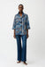 Woman wearing Joseph Ribkoff stripe trapeze jacket with shirred collar, featuring bold vertical stripes, a relaxed flowy fit, and stylish three-quarter sleeves.
