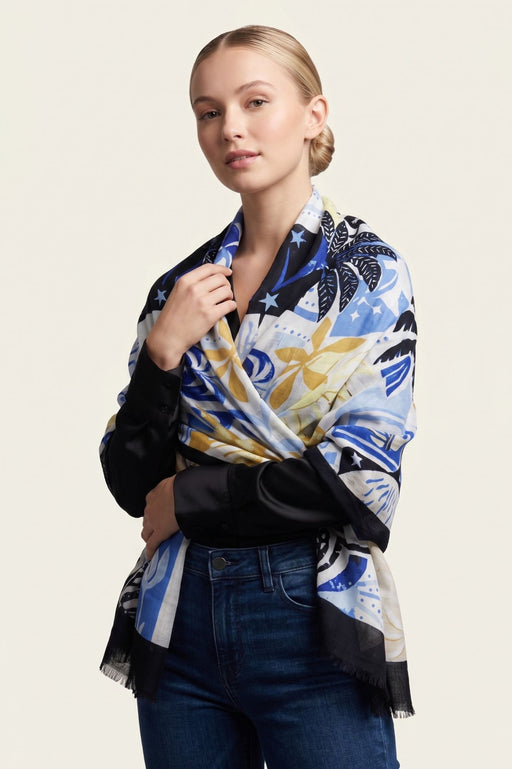 Woman wearing a colorful scarf with tropical print and fringe edges from Joseph Ribkoff