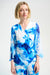 Woman wearing a blue and white floral print wrap top with 3/4 sleeves from Joseph Ribkoff
