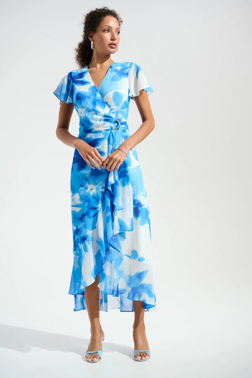 Woman wearing a blue floral wrap dress with high low ruffle hem from Joseph Ribkoff