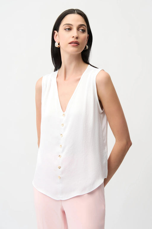 Woman wearing a white sleeveless top with a v-neckline and gold button accents from Joseph Ribkoff