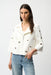 Woman wearing a white zip front jacket with grommet details from Joseph Ribkoff