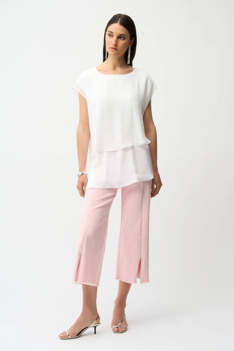 Woman wearing light pink cropped jeans with rhinestone embellishments and frayed hem from Joseph Ribkoff
