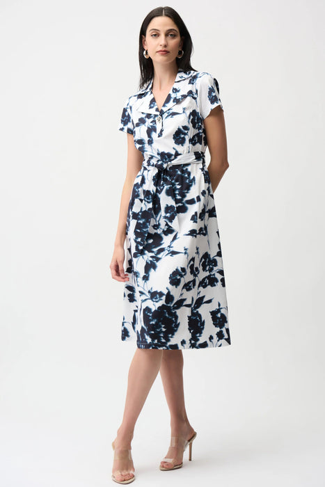 Model wearing Joseph Ribkoff vanilla and midnight blue floral print fit and flare shirt dress with short sleeves and belted waist for an elegant feminine silhouette.